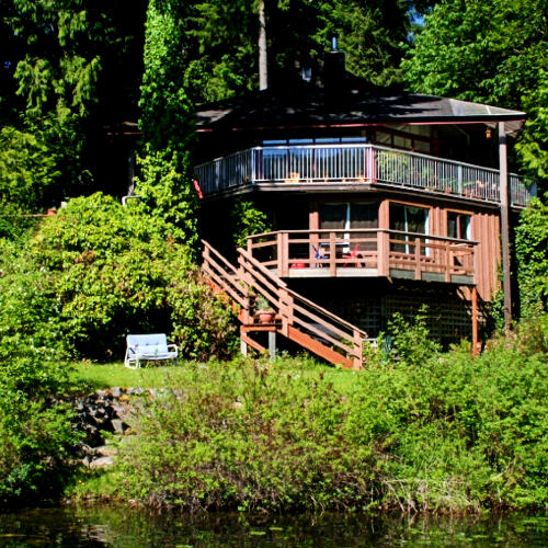Lifestyle Properties photo of lakehouse surrounded by trees and bushes